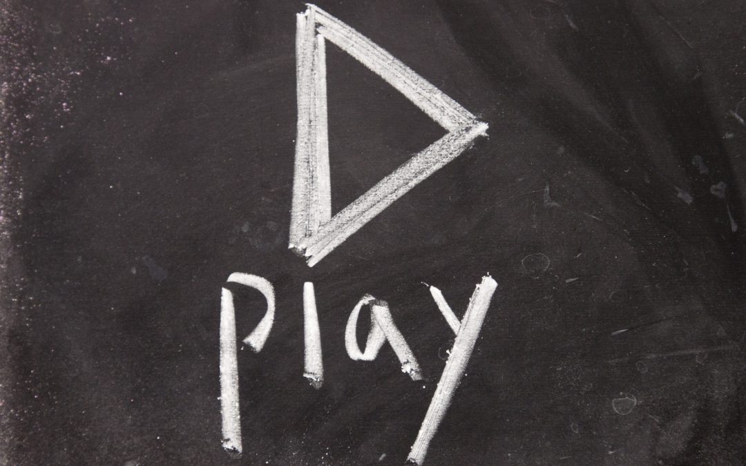 play sign drawn with chalk on blackboard